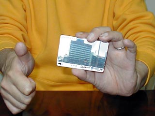 カード片手にサムズアップ